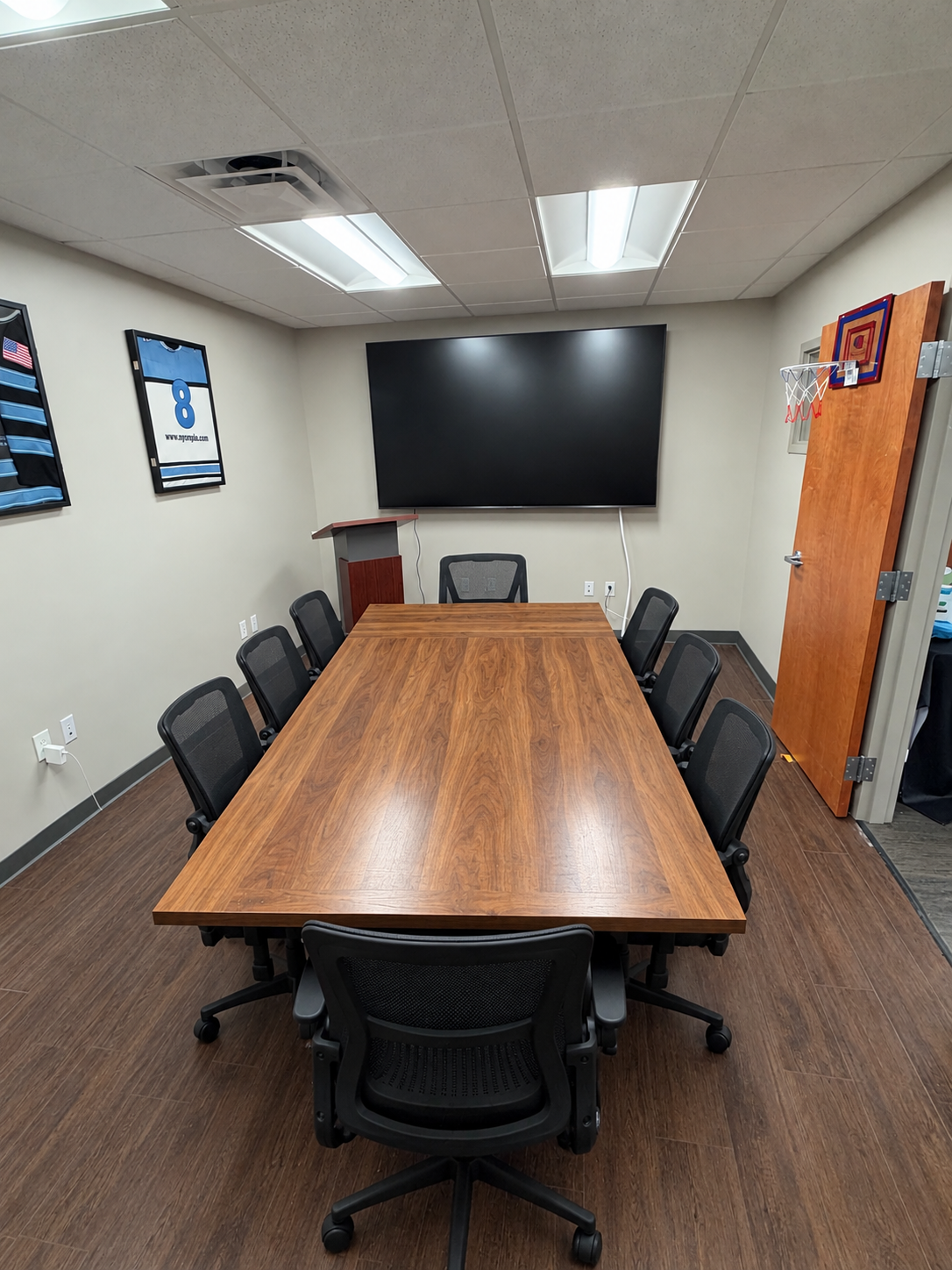 The Anatomy Works discussion room — conference table, task chairs, and a wall-mounted display