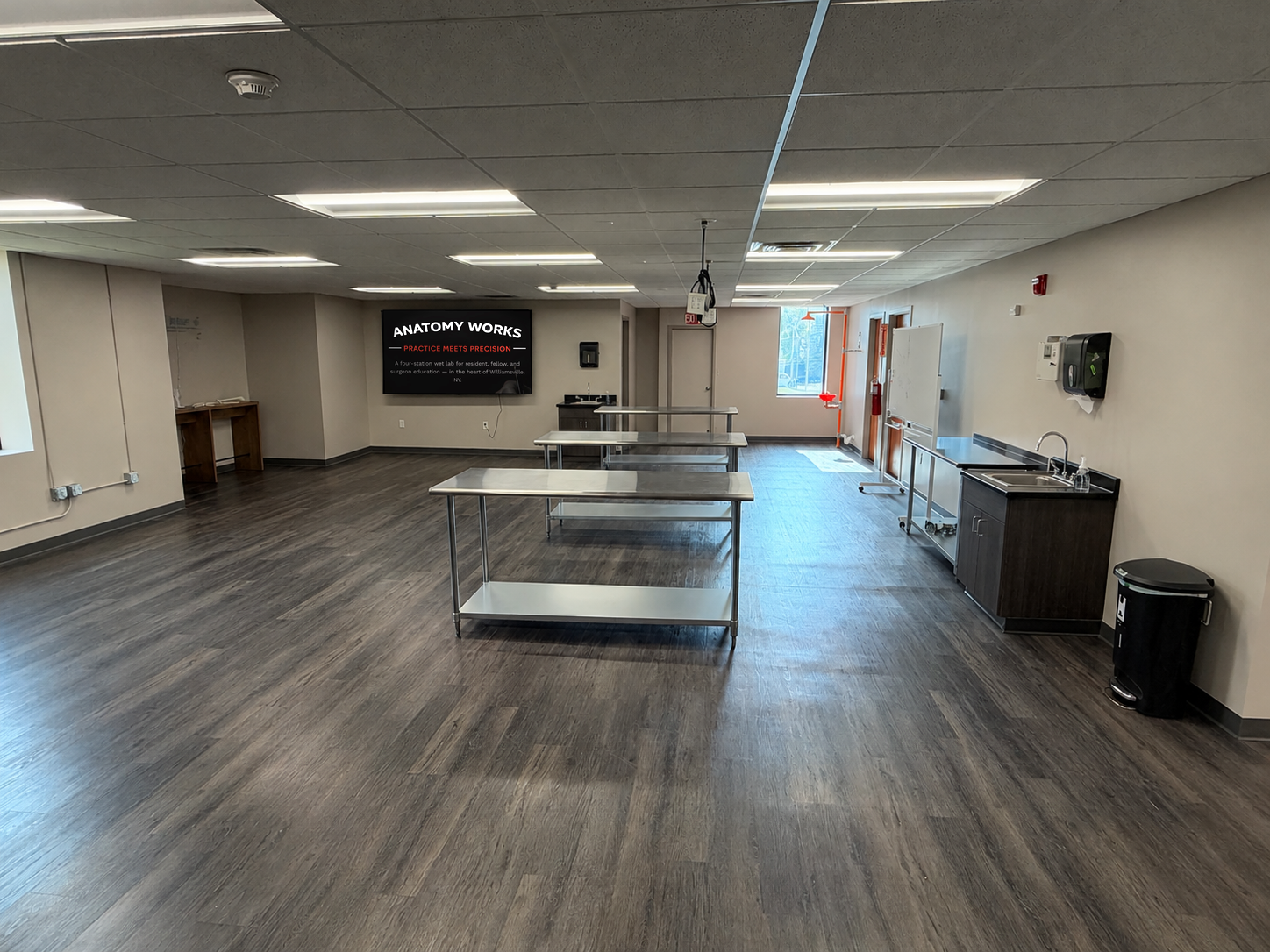 The Anatomy Works workspace — stainless dissection tables, wall-mounted screens, and sinks